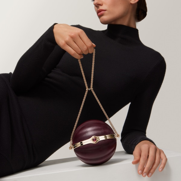 Round bag with gadroon motif, Cartier Soir Burgundy lambskin, hessonite garnet and golden finish