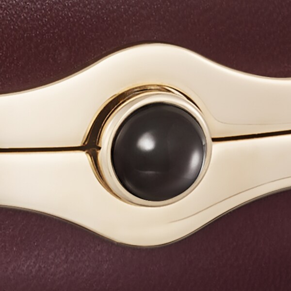 Round bag with gadroon motif, Cartier Soir Burgundy lambskin, hessonite garnet and golden finish
