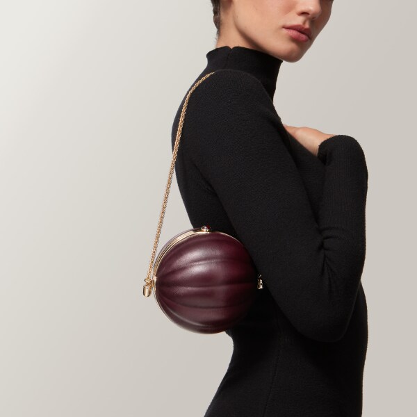 Round bag with gadroon motif, Cartier Soir Burgundy lambskin, hessonite garnet and golden finish